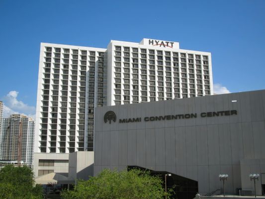Exterior view of the Hyatt and Miami Convention Center under a clear blue sky.